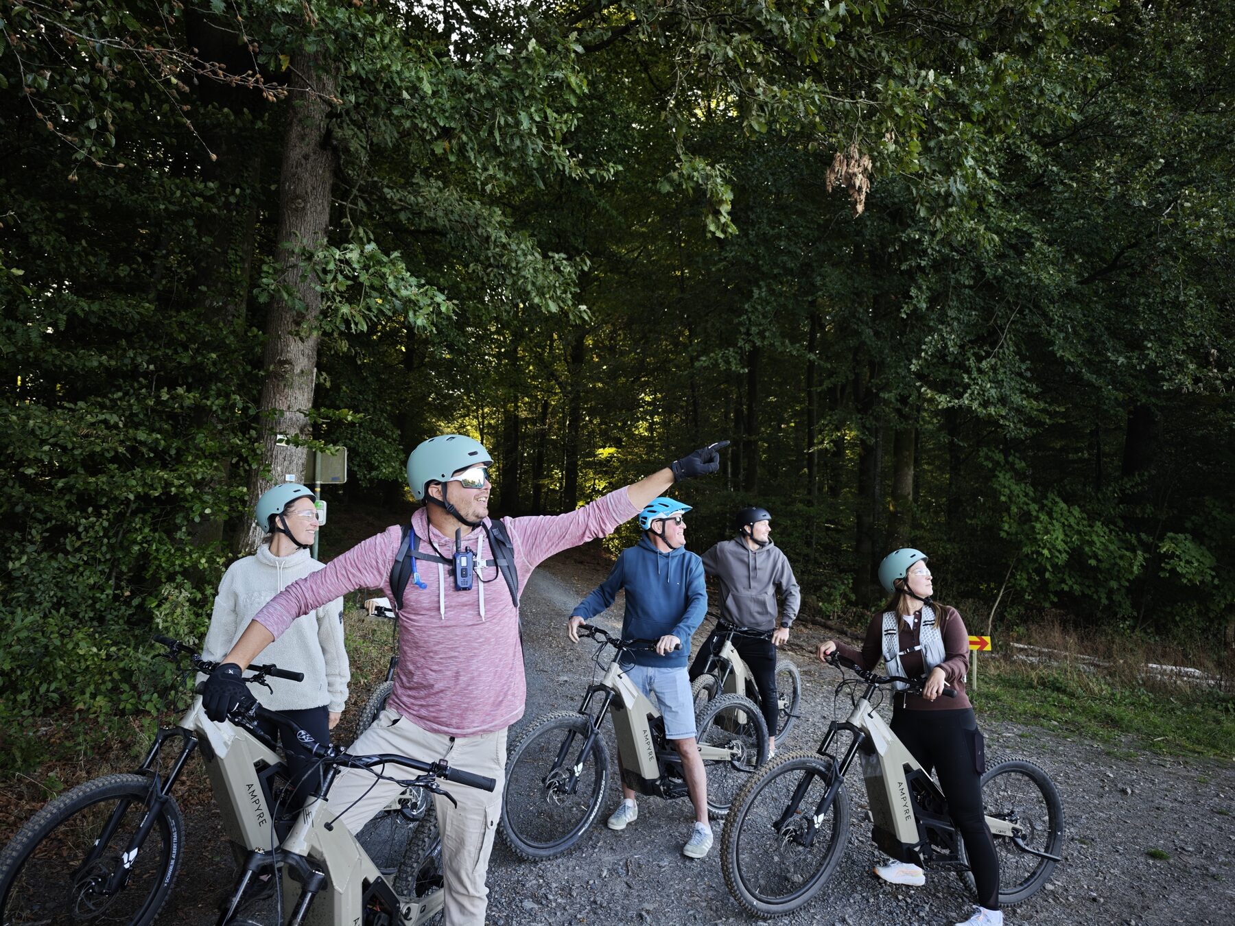 Guide local Gaume Experience accompagnant un groupe en trottinette électrique tout-terrain dans les forêts de la Gaume
